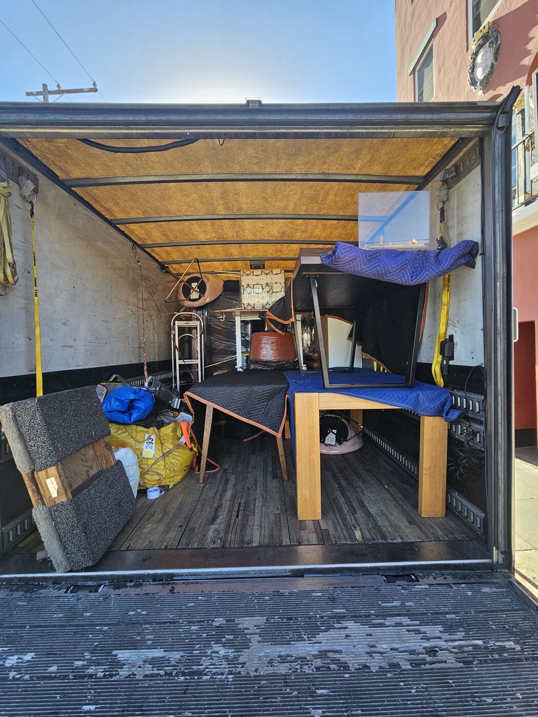 Nearly full box truck professionally packed with wrapped furniture and boxes